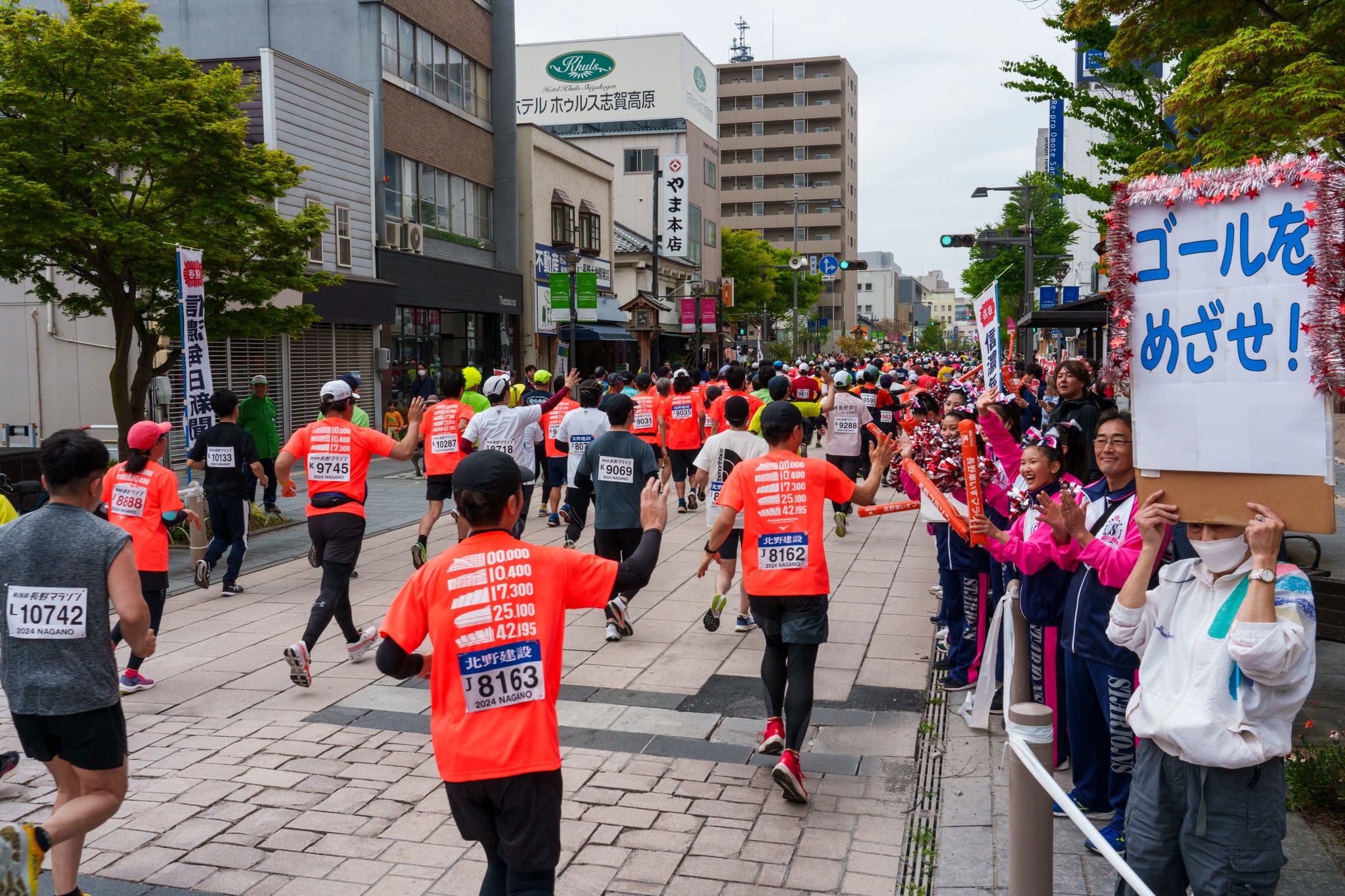 長野馬拉松跑者行經市區街道，兩側民眾熱情揮手加油
