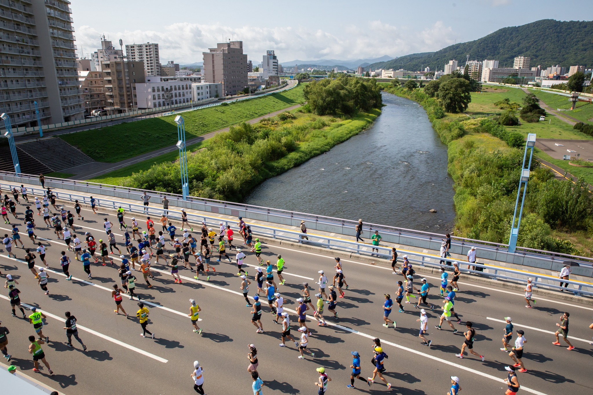 北海道馬拉松跑者行經橋樑,橋下可見河川與遠方山巒