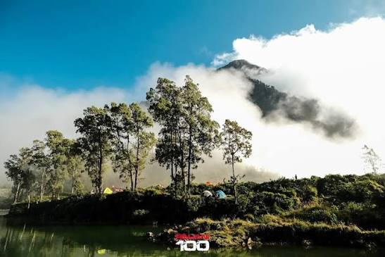林賈尼火山口湖周邊紮營區域，雲霧繚繞的火山稜線在背景
