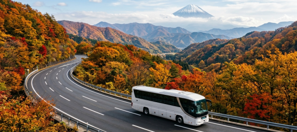 高速巴士行駛於富士山地區山間道路，秋季楓紅與遠方富士山輪廓相映（AI 生成示意圖）
