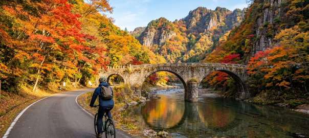 耶馬溪石橋單車道示意圖，秋季紅葉景色（AI 生成示意圖）