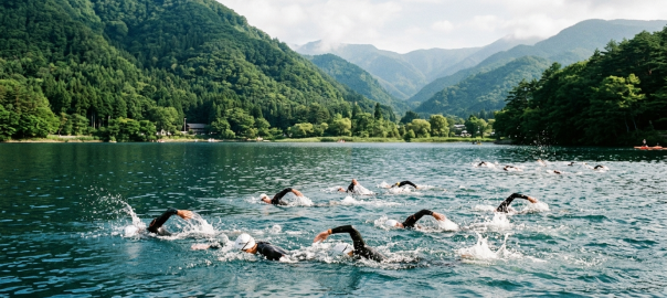 鐵人三項選手於長野野尻湖清澈高山淡水湖破浪海泳遠眺妙高連峰（AI 生成示意圖）